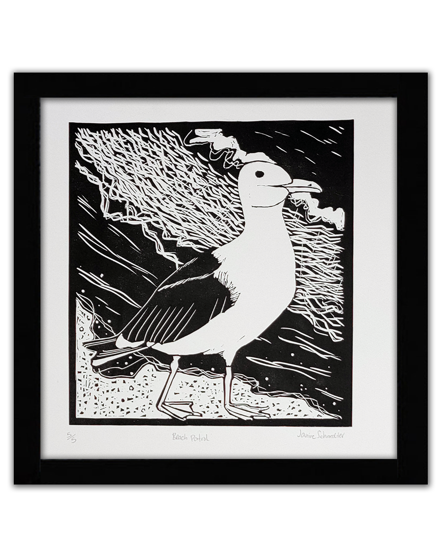 A black linocut of a seagull on the beach
